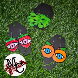 Collection of earrings with leaf patterns, and fruits with eyes. 