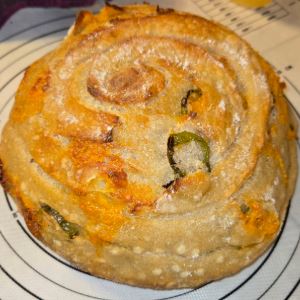 Photo of a croissant with cheese and jalapenos. 