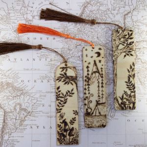 Set of three wooden bookmarks with woodburned images of nature on them.